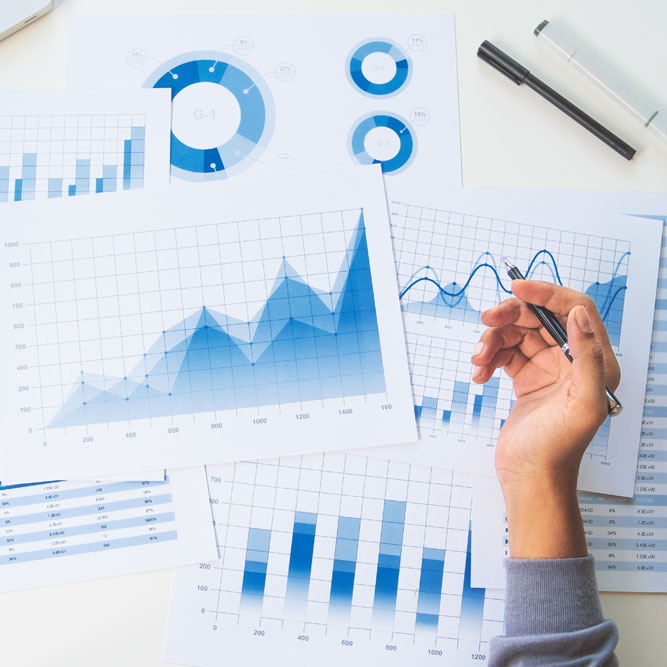 رپورٹوں کے اوپر قلم پکڑے ہاتھ میں